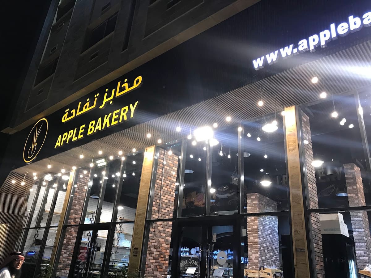 لوحة مخابز تفاحة مضاءة في الليل